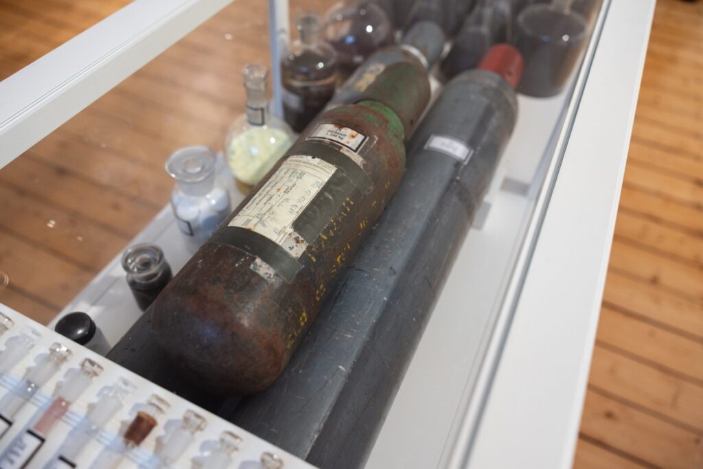 Detailansicht einer Vitrine mit chemischen Elementen in Glas- und Metallbehältern