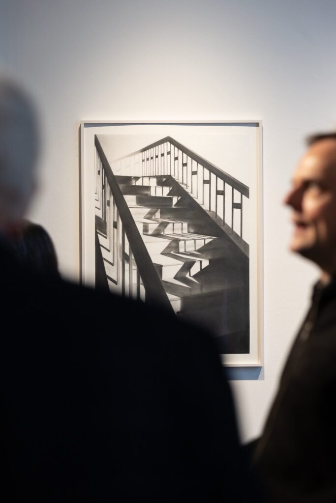 Zwei Besucher stehen vor Graphitzeichnung von Simon Schubert